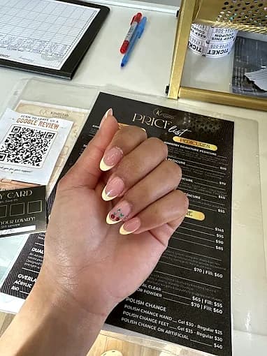 Butter-yellow French tips with a hand-painted cherry accent nail